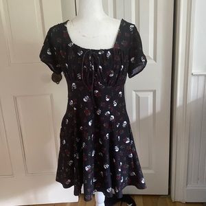 A black dress with pockets and tiny skulls and rose design all over
